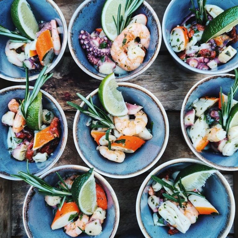 Vielfältige Meeresfrüchte in Schalen, garniert mit Limettenscheiben und Kräutern. Fingerfood